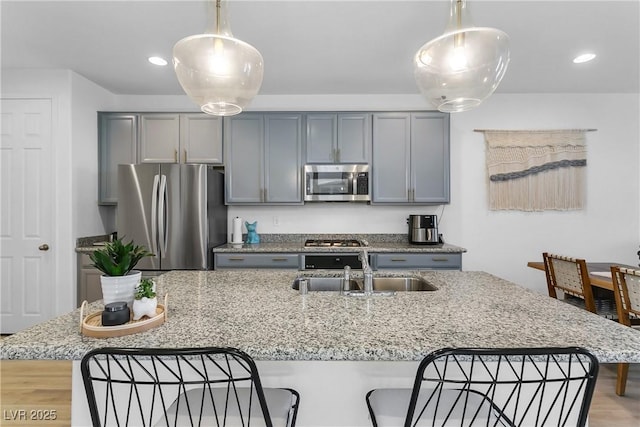 kitchen featuring light stone countertops, hanging light fixtures, and stainless steel appliances