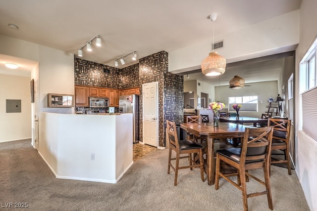 kitchen with decorative light fixtures, light colored carpet, appliances with stainless steel finishes, and electric panel