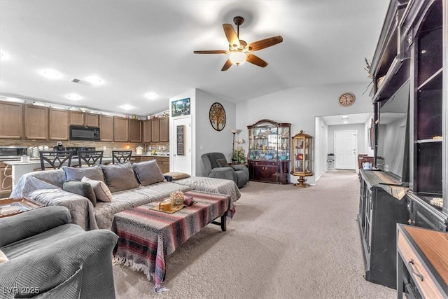 living room with lofted ceiling, light carpet, and ceiling fan