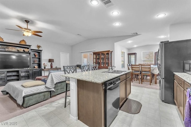 kitchen featuring dishwasher, lofted ceiling, an island with sink, sink, and a breakfast bar