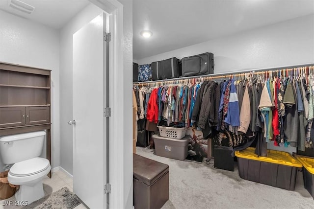 walk in closet featuring light colored carpet