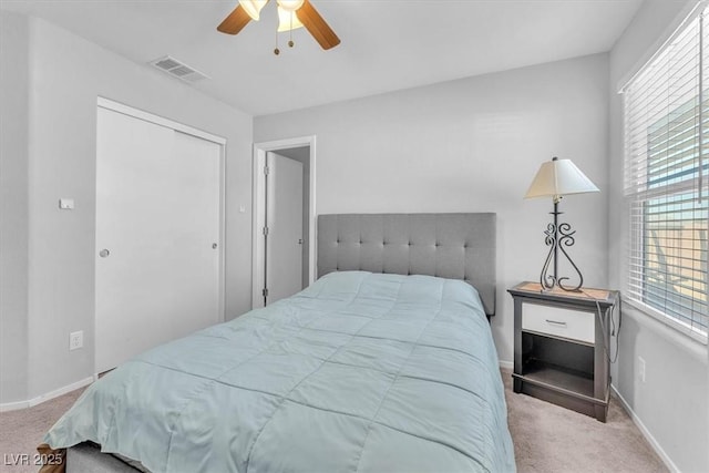 bedroom with ceiling fan, a closet, and light carpet