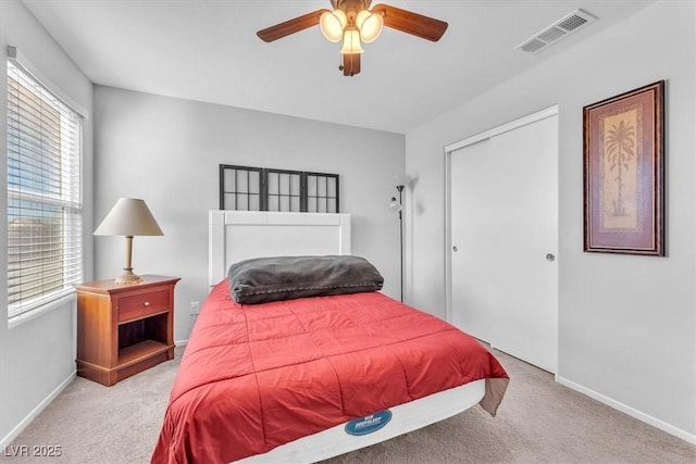 bedroom featuring light carpet, ceiling fan, and a closet