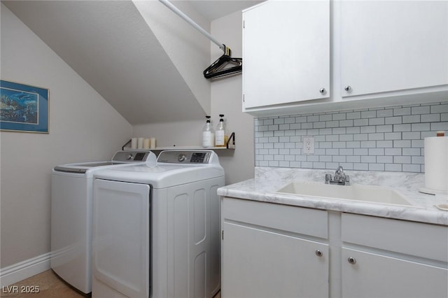 clothes washing area featuring washer and dryer, sink, and cabinets