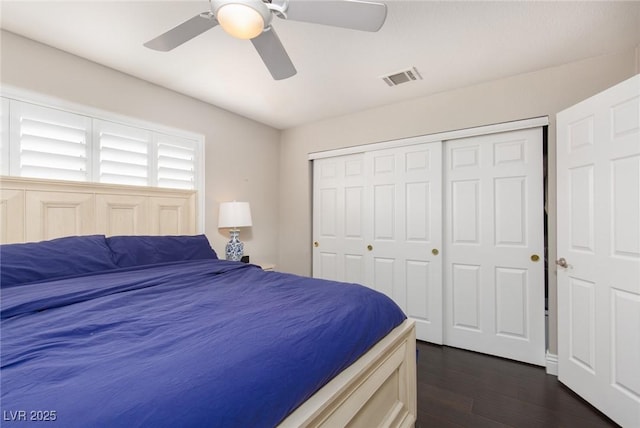 bedroom with dark hardwood / wood-style floors, ceiling fan, and a closet