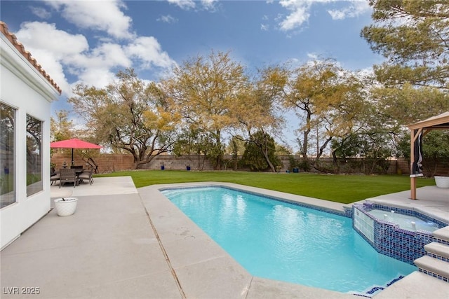 view of pool featuring a yard, a patio area, and an in ground hot tub