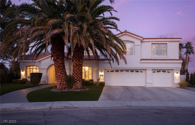 mediterranean / spanish-style house with a garage