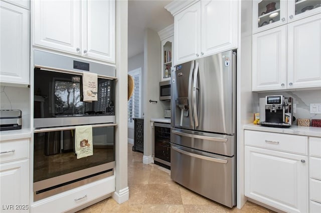 kitchen featuring light tile patterned flooring, appliances with stainless steel finishes, white cabinets, and beverage cooler