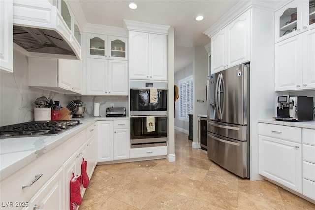 kitchen featuring stainless steel appliances, premium range hood, and white cabinets