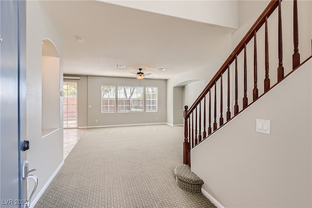 foyer featuring ceiling fan and light colored carpet