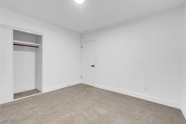 unfurnished bedroom featuring a textured ceiling, a closet, and carpet flooring