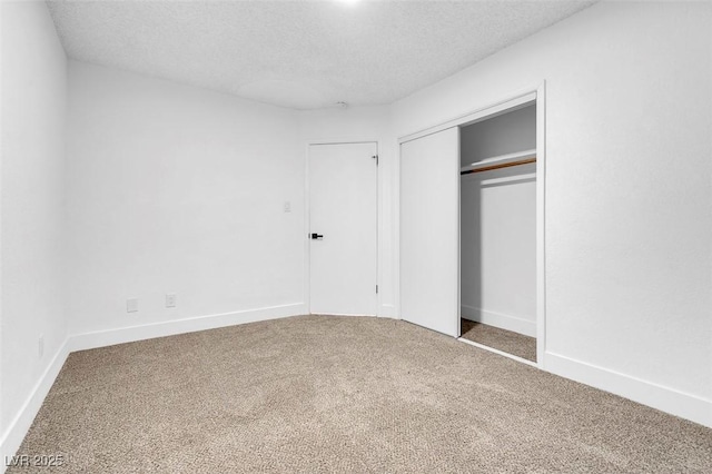 unfurnished bedroom featuring carpet, a closet, and a textured ceiling