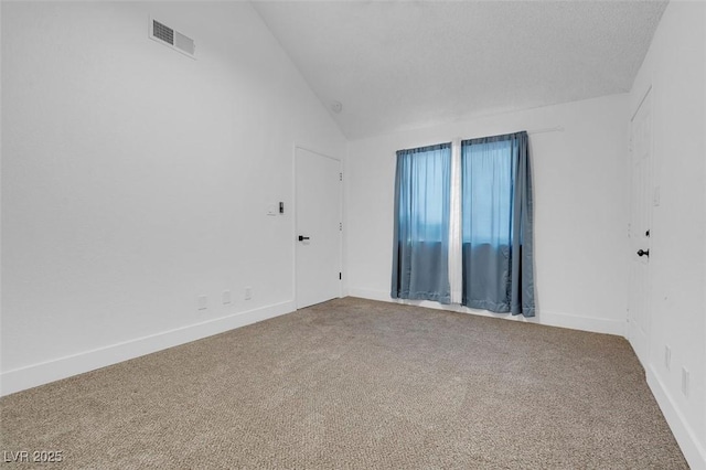 carpeted spare room with lofted ceiling