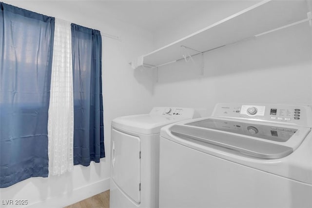 laundry room featuring separate washer and dryer and light hardwood / wood-style flooring