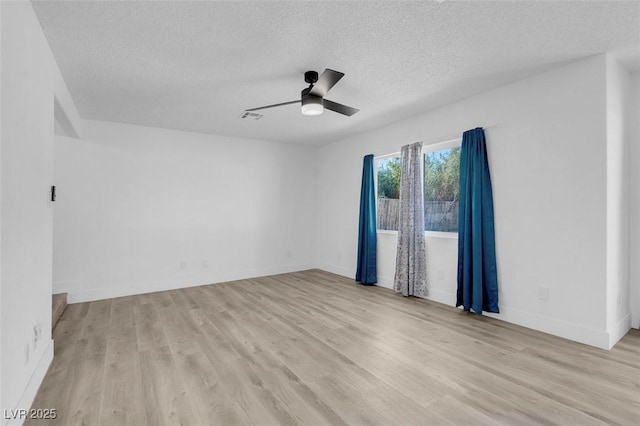 empty room with ceiling fan, a textured ceiling, and light hardwood / wood-style flooring