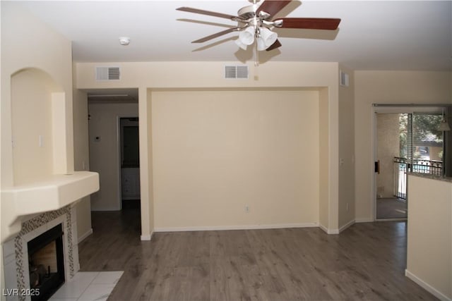 unfurnished living room with hardwood / wood-style flooring, ceiling fan, and a fireplace