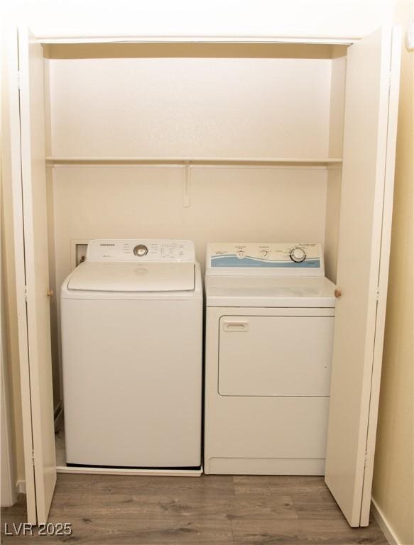 laundry area featuring separate washer and dryer and hardwood / wood-style flooring