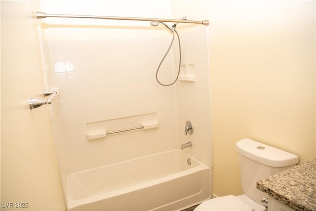 bathroom featuring toilet and tiled shower / bath