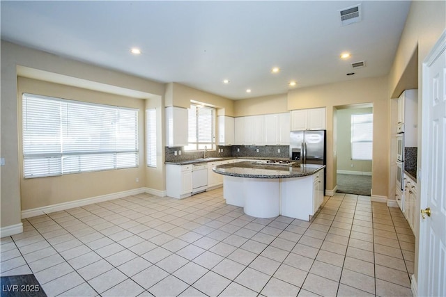 kitchen featuring a center island, light tile patterned floors, white cabinets, sink, and stainless steel appliances