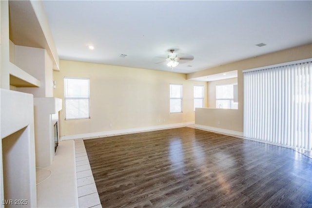 unfurnished living room with ceiling fan and dark hardwood / wood-style floors