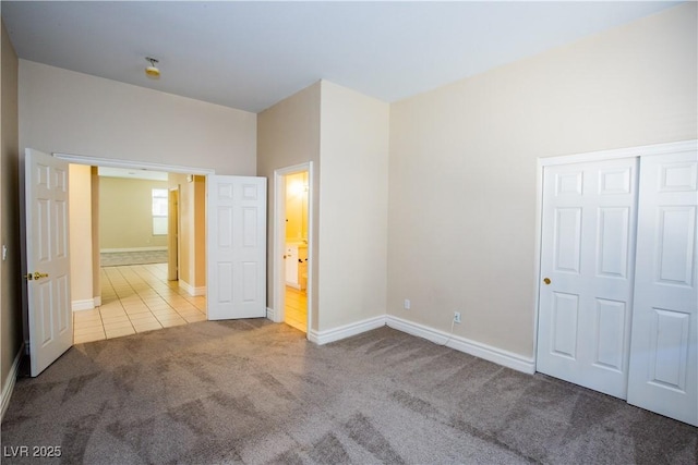 unfurnished bedroom featuring light carpet and a closet