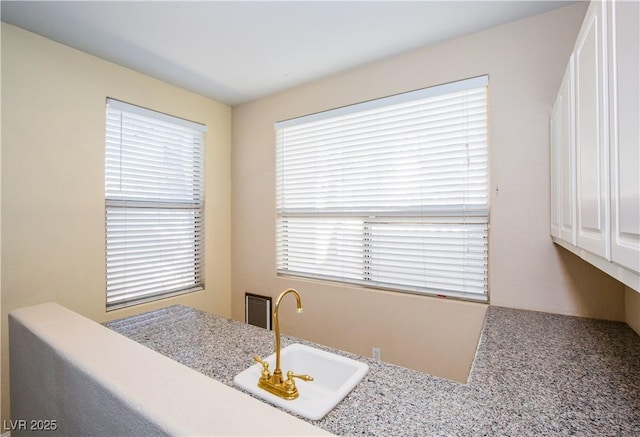 kitchen featuring sink, carpet flooring, and white cabinetry