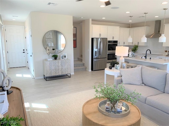 living room with sink and light wood-type flooring