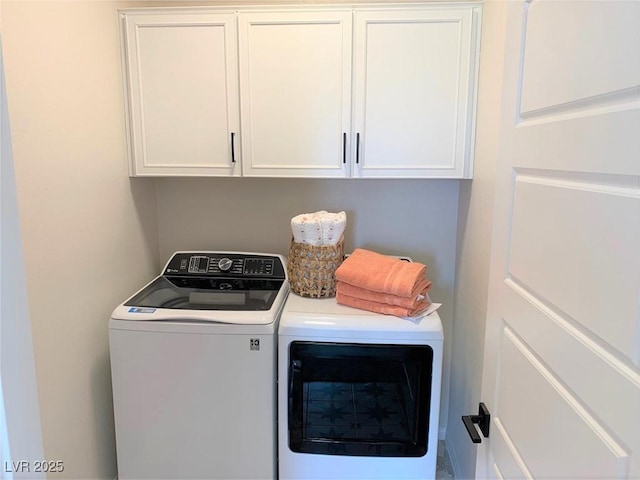 laundry room with separate washer and dryer and cabinets