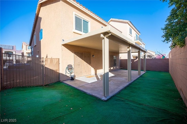 back of house featuring a patio area, a fenced backyard, a tile roof, and stucco siding