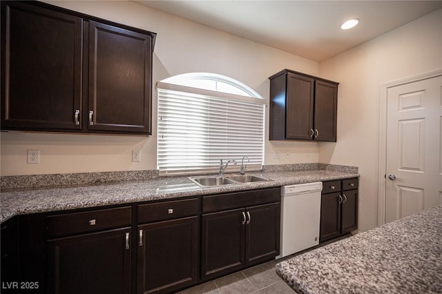 kitchen with white dishwasher, dark brown cabinets, a sink, and recessed lighting