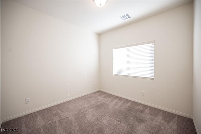 carpeted empty room featuring baseboards and visible vents