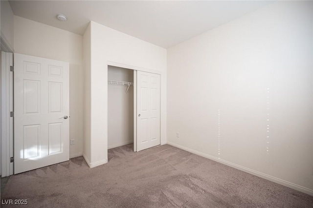 unfurnished bedroom with a closet, carpet flooring, and baseboards