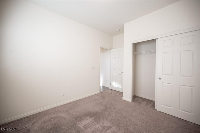 unfurnished bedroom featuring carpet, baseboards, and a closet