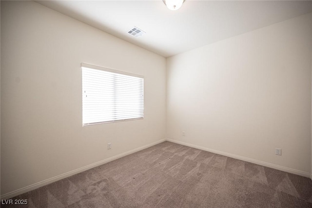 spare room with carpet floors, baseboards, and visible vents