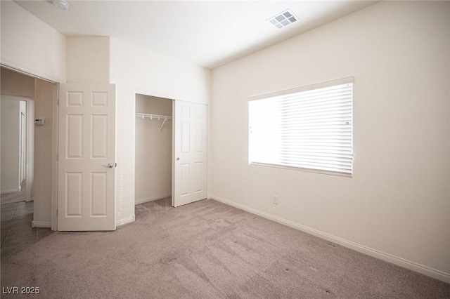 unfurnished bedroom featuring carpet floors, baseboards, visible vents, and a closet