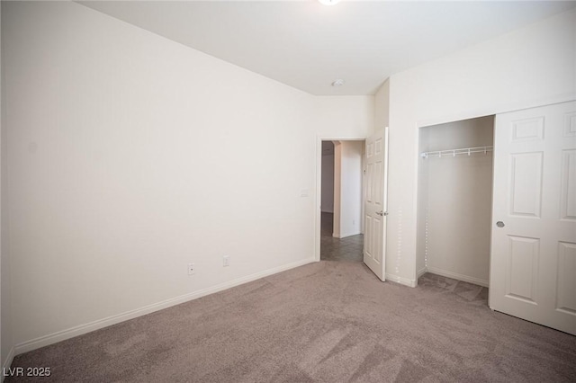 unfurnished bedroom with baseboards, carpet floors, and a closet