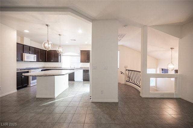 kitchen with a center island, a notable chandelier, dark brown cabinetry, white appliances, and dark tile patterned floors