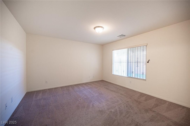 spare room featuring carpet, visible vents, and baseboards