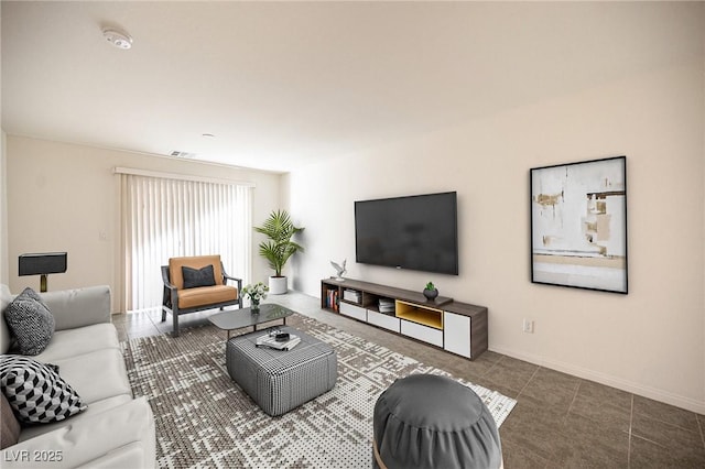 living area with tile patterned floors, visible vents, and baseboards