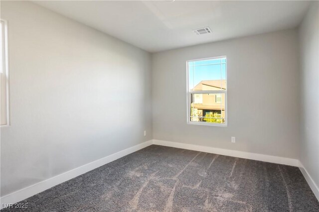 spare room featuring dark colored carpet