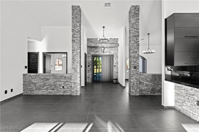 interior space featuring dark tile patterned flooring and a high ceiling