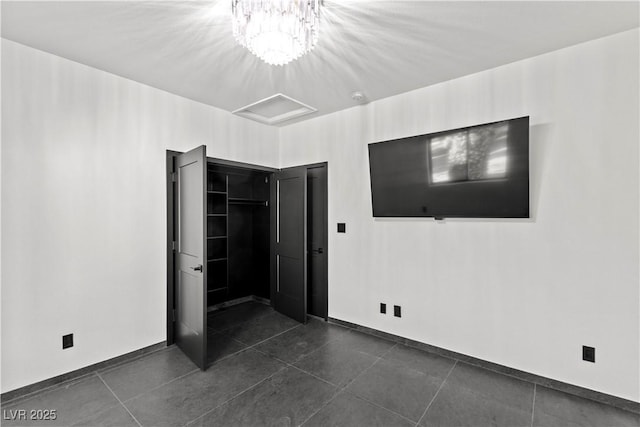 unfurnished bedroom featuring a closet and a notable chandelier