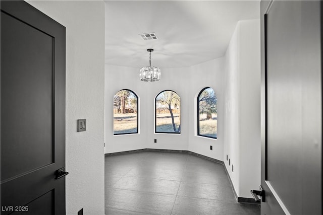 unfurnished room with a chandelier