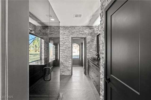 bathroom featuring a healthy amount of sunlight and a shower with door