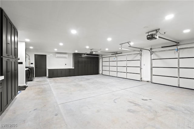 garage featuring washer / clothes dryer, an AC wall unit, and a garage door opener