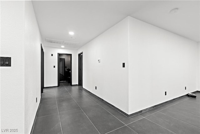 corridor with dark tile patterned flooring