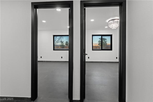 hall featuring plenty of natural light and a chandelier