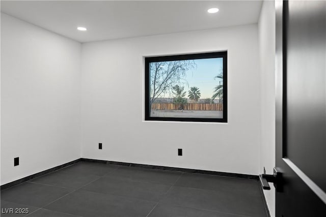 unfurnished room featuring dark tile patterned flooring