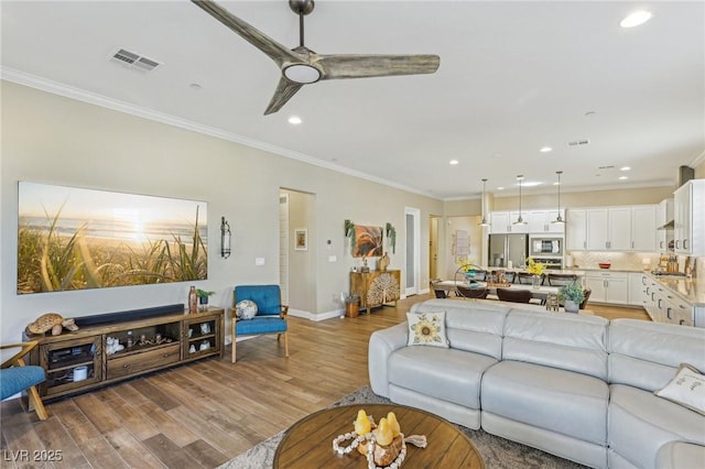 living room with ceiling fan, crown molding, and light hardwood / wood-style floors