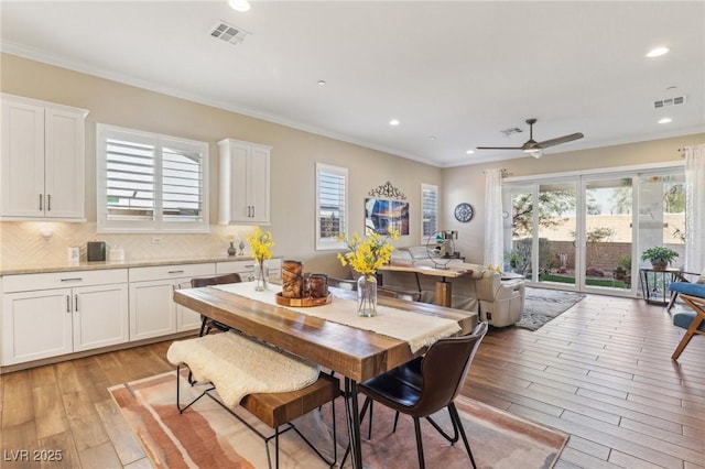 dining room with ceiling fan, ornamental molding, and light hardwood / wood-style flooring